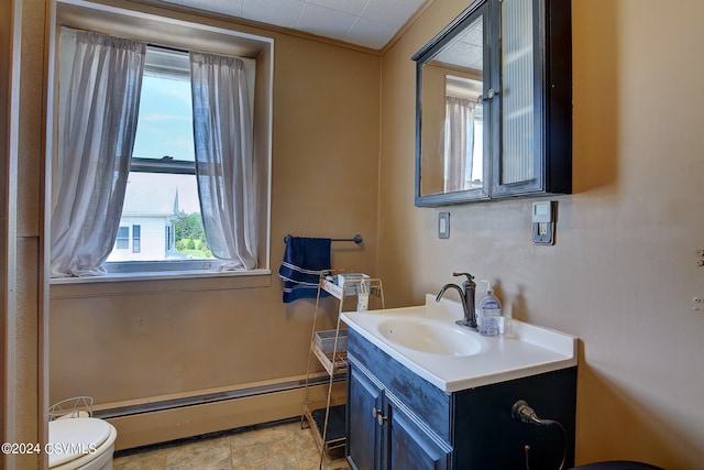 bathroom featuring vanity, tile patterned flooring, baseboard heating, and toilet