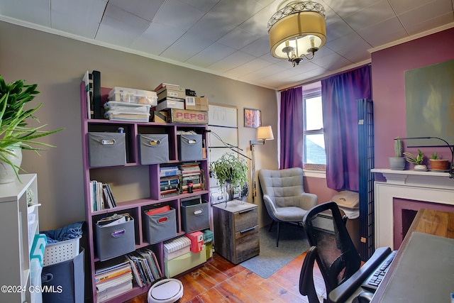 office area with light hardwood / wood-style floors and crown molding