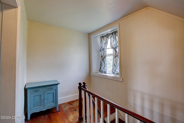 hallway with dark wood-type flooring and lofted ceiling