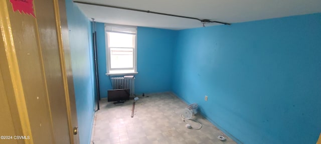 unfurnished room featuring radiator heating unit