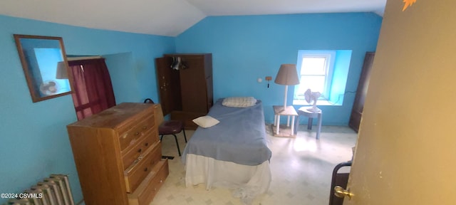 bedroom with vaulted ceiling and radiator