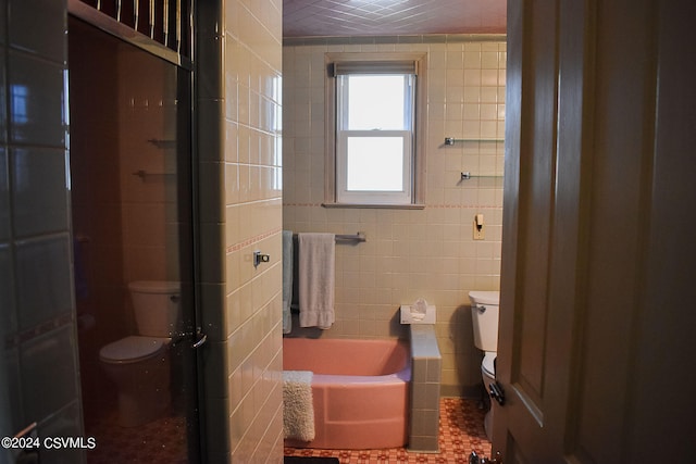 bathroom with tile patterned floors, tile walls, toilet, and a tub to relax in