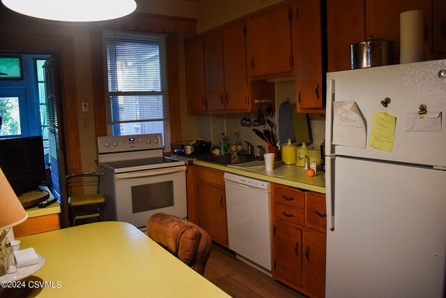 kitchen with white appliances, sink, and hardwood / wood-style floors