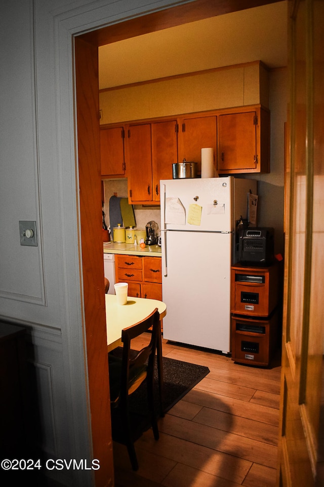 kitchen featuring light wood-type flooring and white appliances