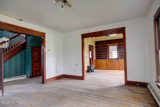 interior space featuring baseboard heating, built in features, and hardwood / wood-style flooring