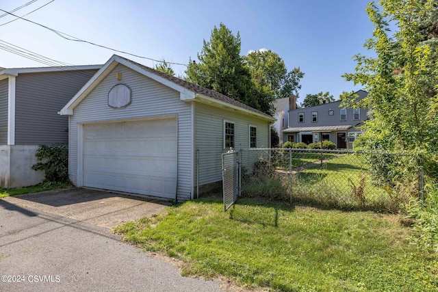 view of front facade featuring a front yard, a garage, and an outbuilding