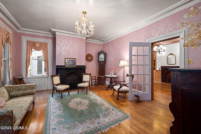 interior space featuring a fireplace, an inviting chandelier, hardwood / wood-style floors, and ornamental molding