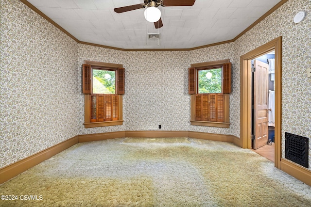 carpeted empty room with a wealth of natural light, ceiling fan, and ornamental molding