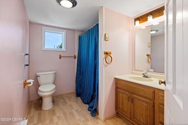 bathroom featuring wood-type flooring, toilet, and vanity