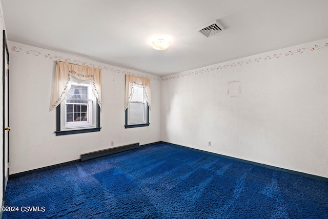 spare room featuring carpet flooring and a baseboard heating unit