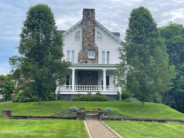 victorian-style house featuring a front yard and a porch