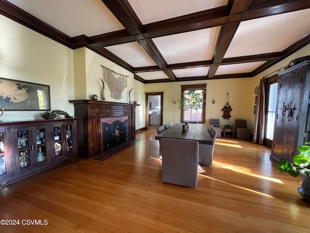 interior space featuring a fireplace, light wood-type flooring, coffered ceiling, and a center island