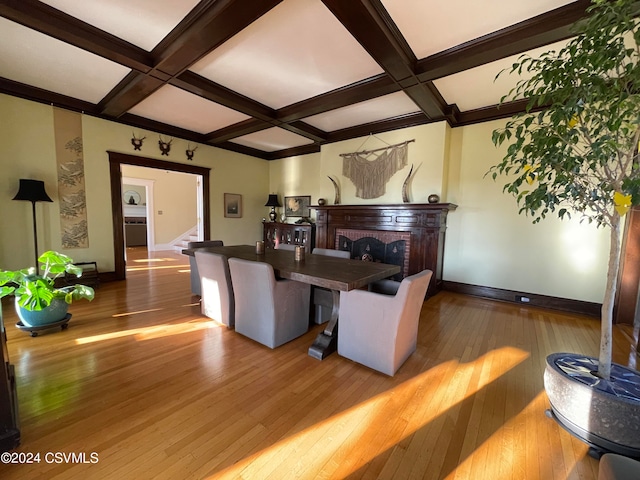 living room with a brick fireplace, wood-type flooring, beam ceiling, and coffered ceiling