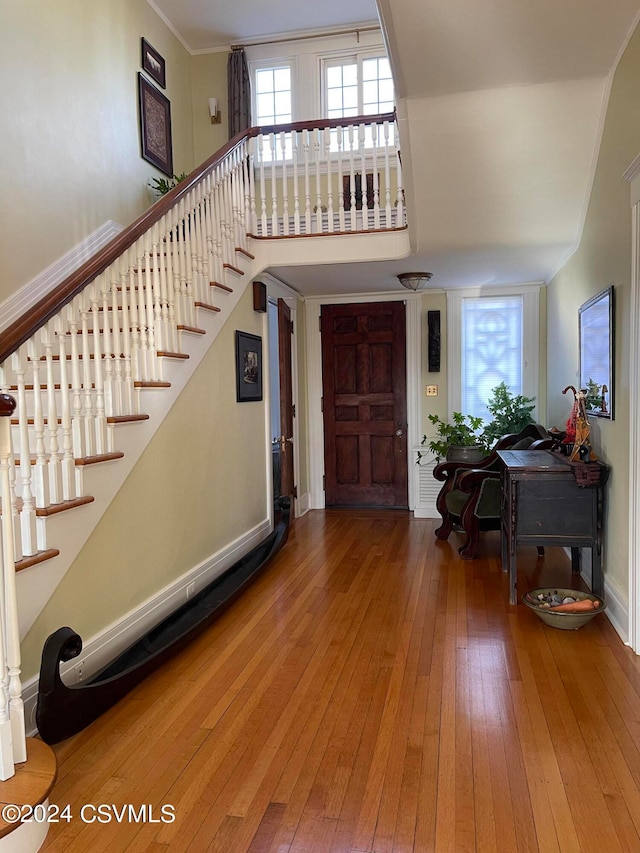 foyer entrance featuring a wealth of natural light, wood-type flooring, and ornamental molding