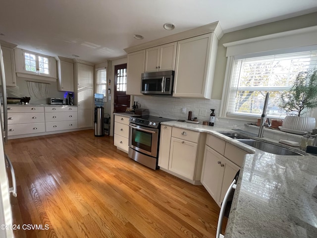 kitchen featuring white cabinets, appliances with stainless steel finishes, and light hardwood / wood-style floors