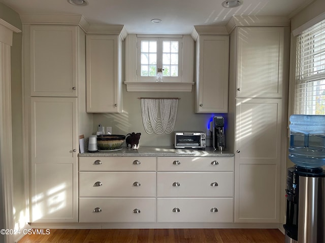 kitchen featuring wood-type flooring and white cabinets