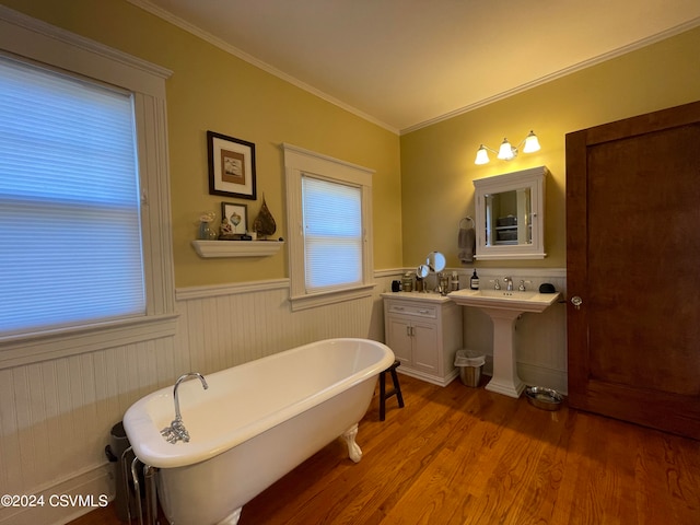 bathroom featuring ornamental molding, hardwood / wood-style flooring, sink, and a tub to relax in