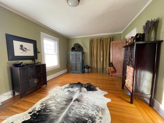 bedroom featuring light wood-type flooring and crown molding