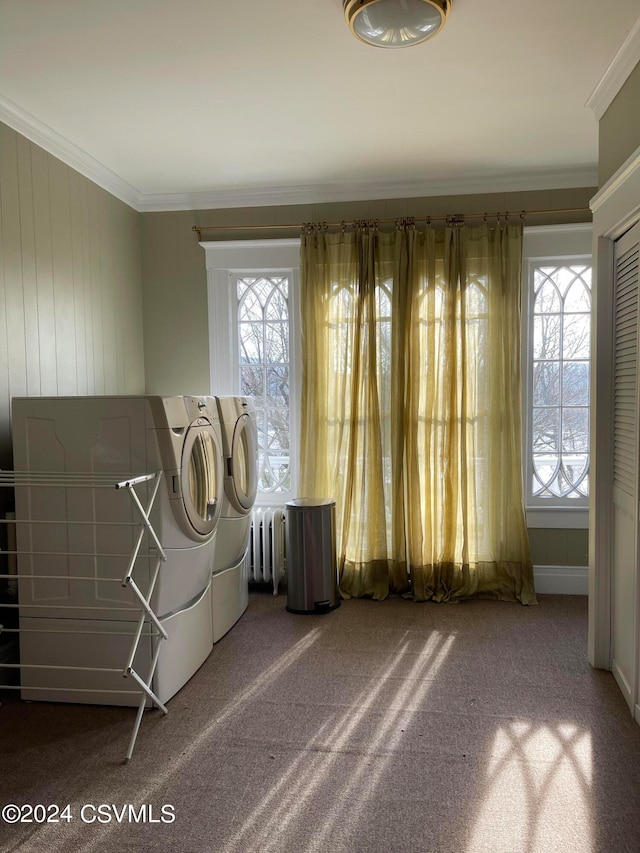 clothes washing area featuring carpet, plenty of natural light, radiator heating unit, and washer and dryer