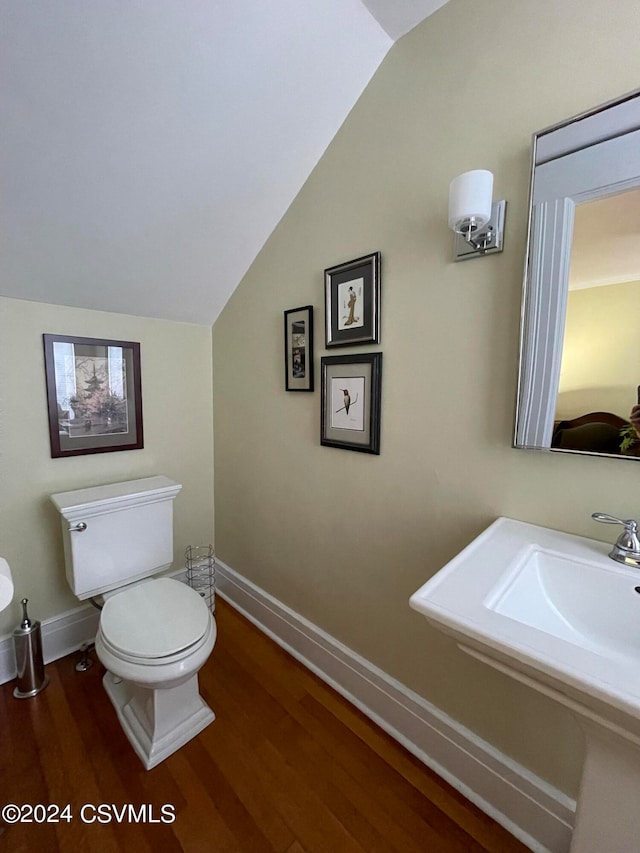 bathroom featuring toilet, lofted ceiling, and hardwood / wood-style floors