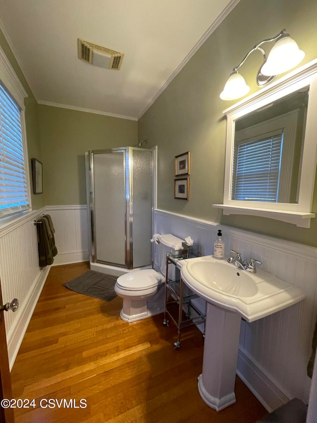 bathroom with ornamental molding, walk in shower, wood-type flooring, and toilet