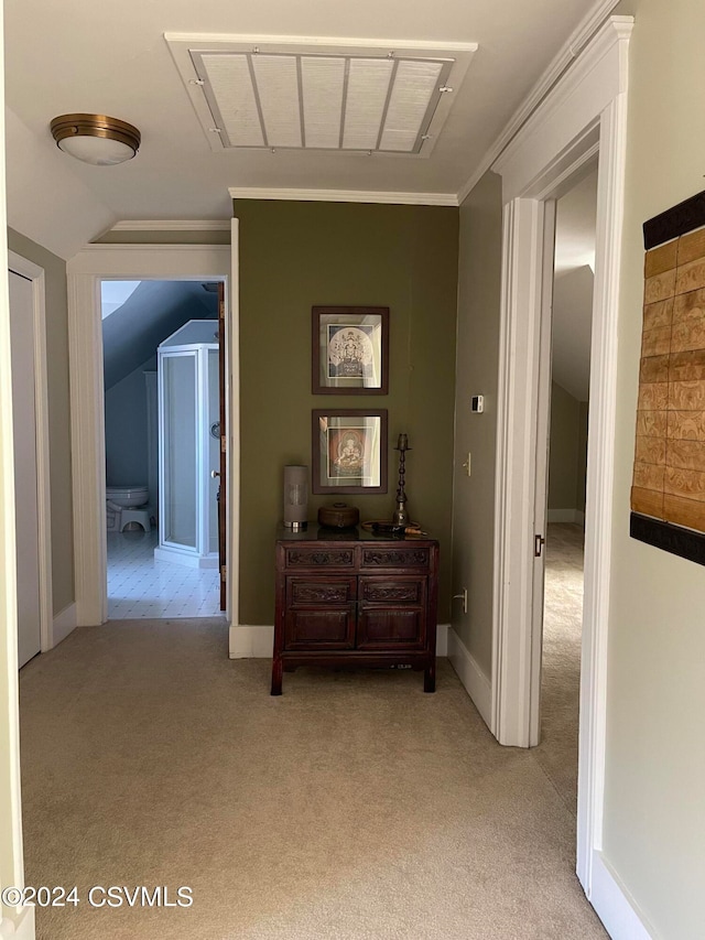 hallway featuring vaulted ceiling, light colored carpet, and ornamental molding