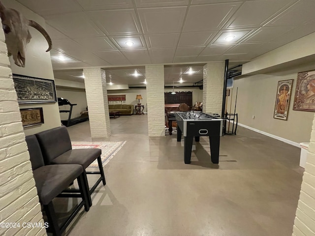 game room with ornate columns and concrete flooring