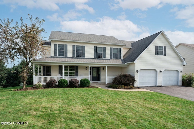 view of front of house with covered porch, a garage, and a front lawn