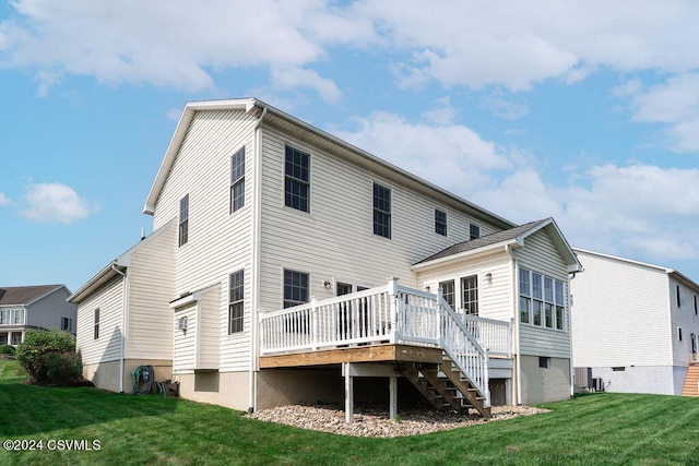 rear view of house featuring central AC unit, a wooden deck, and a lawn