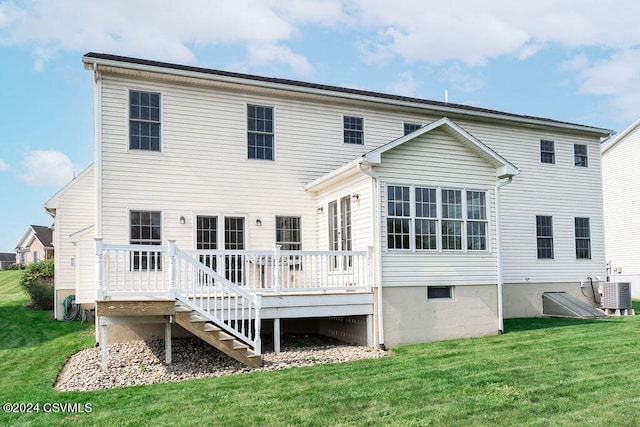 back of property with a wooden deck, central air condition unit, and a lawn