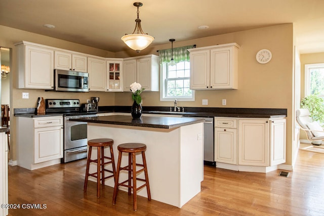 kitchen featuring a wealth of natural light, light hardwood / wood-style flooring, white cabinetry, and stainless steel appliances