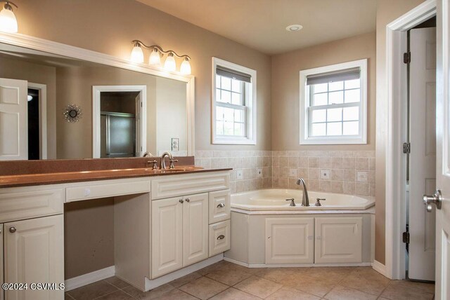 bathroom with tile patterned floors, vanity, and shower with separate bathtub