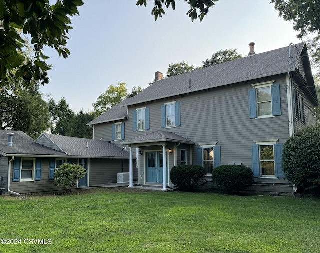 view of front of home featuring a front yard and cooling unit