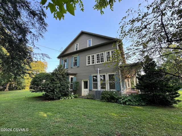 exterior space featuring central AC and a lawn