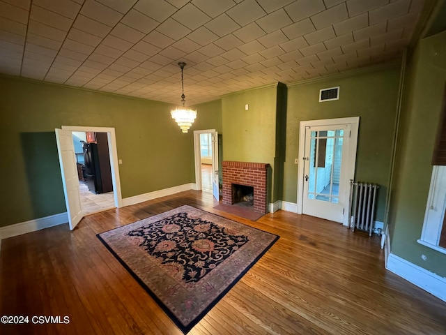 living room with crown molding, hardwood / wood-style floors, and radiator