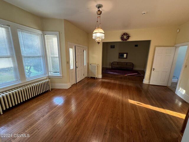 interior space featuring a notable chandelier, dark hardwood / wood-style floors, and radiator