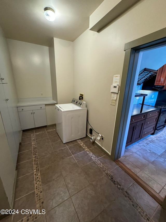 clothes washing area with dark tile patterned flooring and washer / clothes dryer