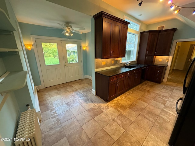 kitchen with dark brown cabinets, ceiling fan, backsplash, radiator, and sink