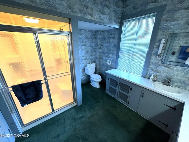 bathroom featuring toilet, an enclosed shower, and vanity