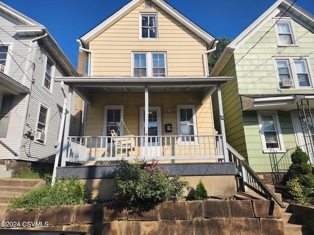 view of front of property featuring cooling unit and a porch