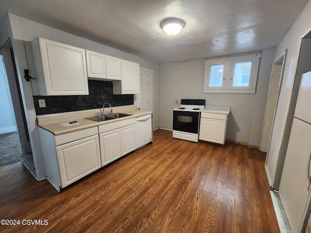 kitchen with white appliances, backsplash, wood-type flooring, sink, and white cabinets