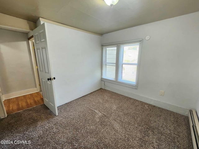 unfurnished bedroom featuring a baseboard radiator and carpet flooring