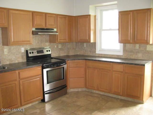 kitchen with stainless steel electric range, tasteful backsplash, and sink