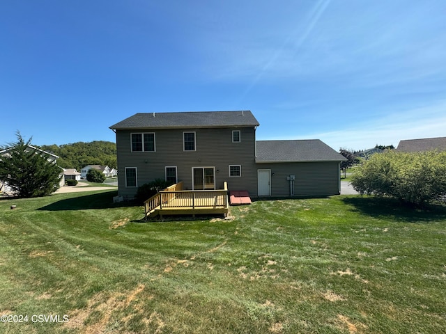 rear view of property with a deck and a lawn