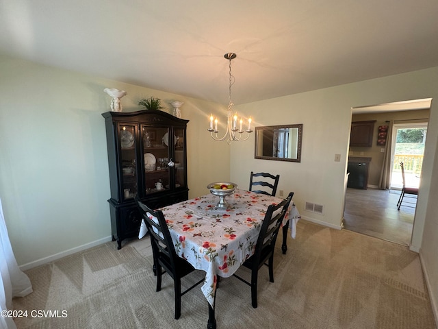 dining space featuring light colored carpet and an inviting chandelier