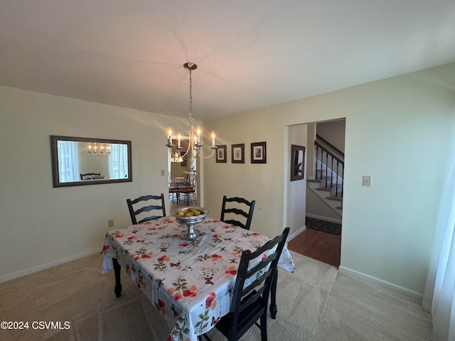 carpeted dining area featuring an inviting chandelier