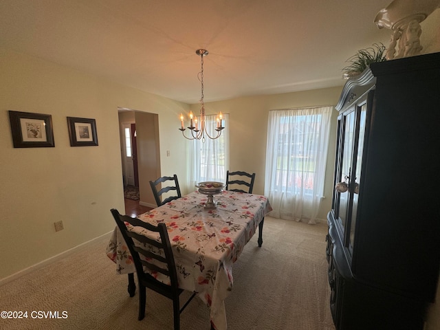 dining room with a chandelier and carpet flooring