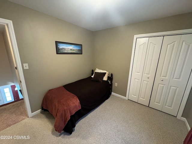 bedroom with light colored carpet and a closet