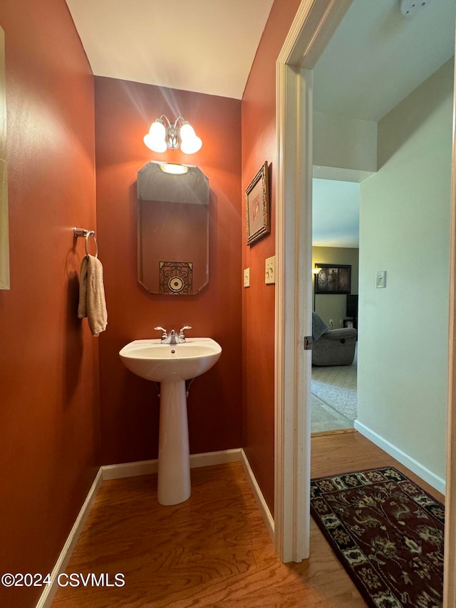 bathroom featuring wood-type flooring and a chandelier