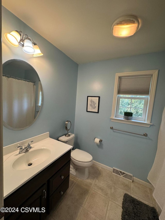 bathroom with vanity, toilet, and tile patterned floors